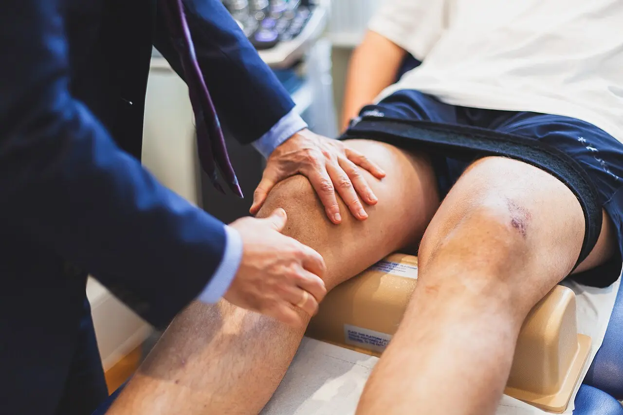 A sports medicine doctor assessing an athlete’s knee